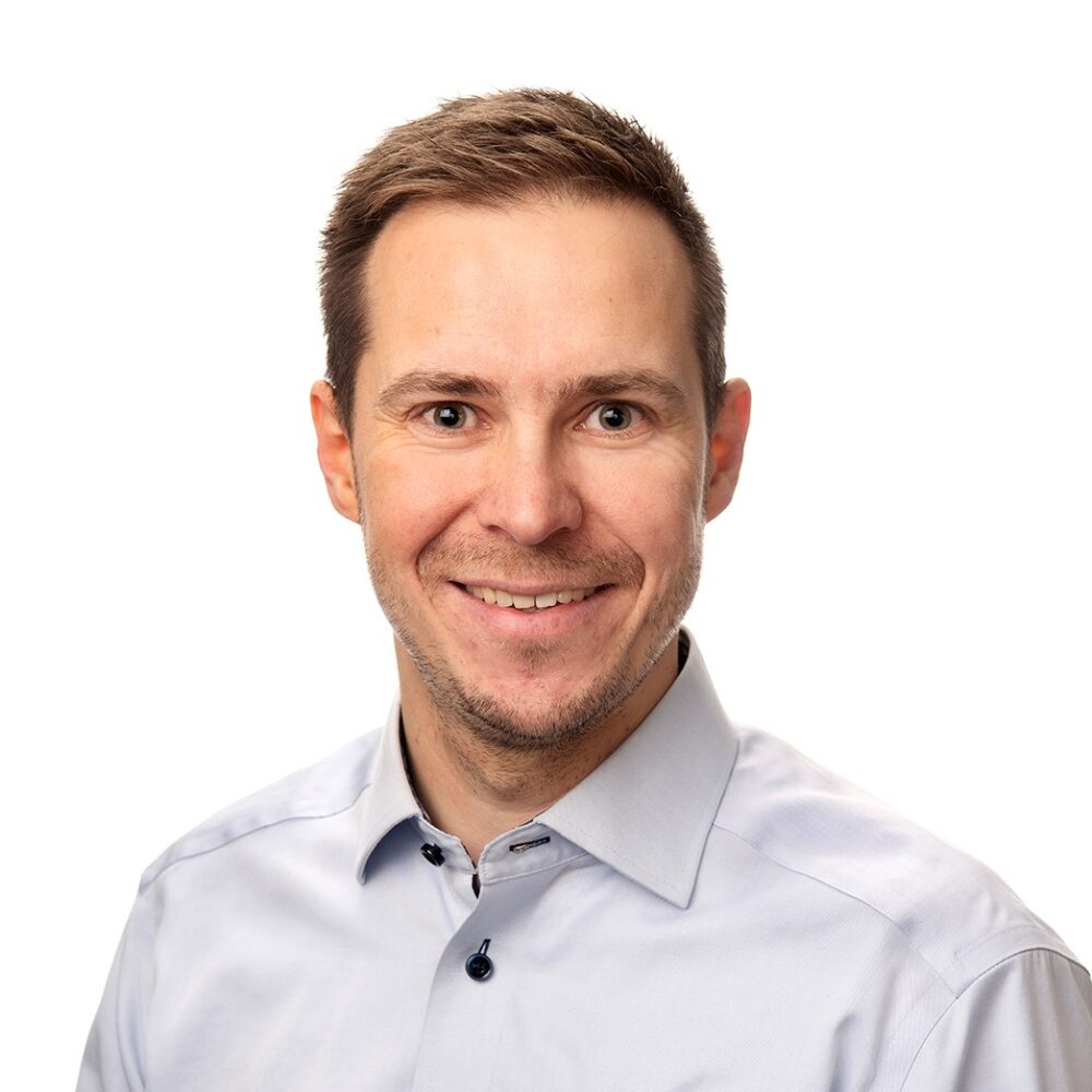 A man looks at the camera and smiles.