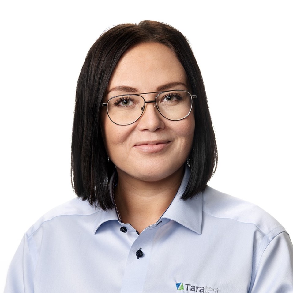A woman wearing glasses looks at the camera and smiles.